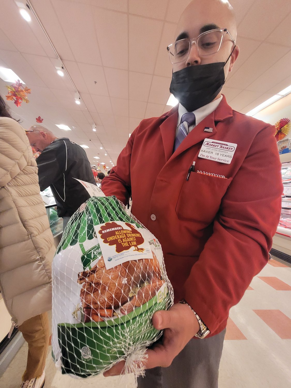 WARNING BIRD: Xavier Taylor, Market Basket’s assistant store manager in Johnston, holds a freshly stickered turkey.